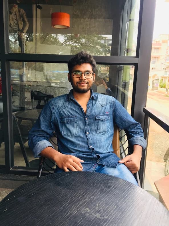 Aditya Raman sitting at a café table by a window
